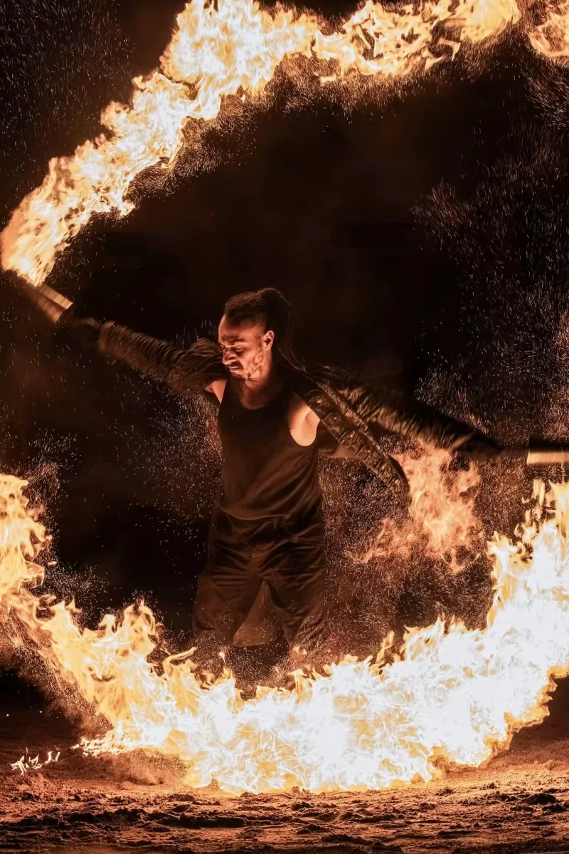 Artiste entouré d’un cercle de feu pendant une scène intense du spectacle Eden.