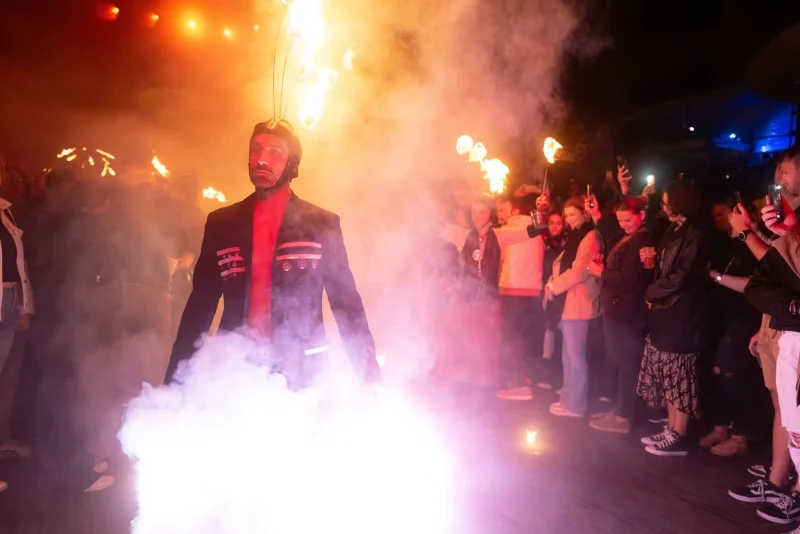 Artiste avançant dans la fumée et les flammes devant le public pendant le spectacle Eden.