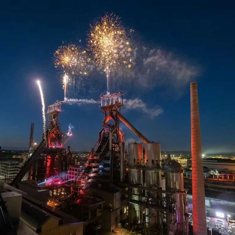 Effets pyrotechniques et fontaines d’étincelles sur une structure métallique élevée pendant le spectacle Horizons.