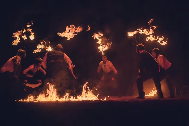 Artistes réunis autour d’un cercle de feu avec crete de feu, dans une scène rituelle du spectacle Horizons.