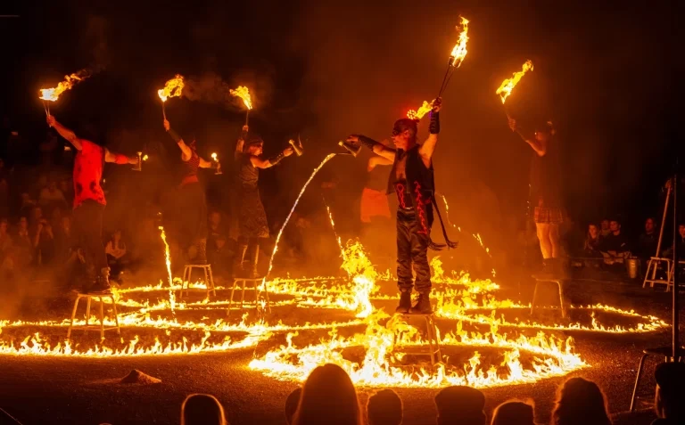 Groupe d'artistes sur des tabourets avec le sol totalement enflammé avec du feu liquide.