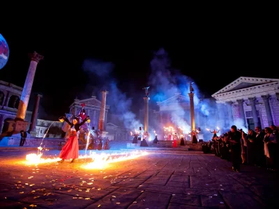 Artistes en train de faire couler du feu devant un monument antique