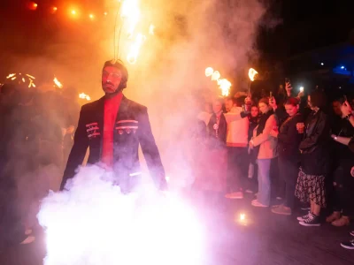Artiste avançant dans la fumée et les flammes devant le public pendant le spectacle Eden.